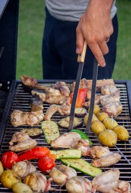 Bir adam et ve sebze pişiriyor. Seçici odaklanma. Doğa