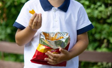 Patates cipsi yiyen çocuk. Seçici odaklanma. Doğa