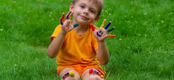 a smile painted with paints on the child's arms and legs. Selective focus