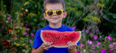 A child eats a watermelon. Selective focus. Nature
