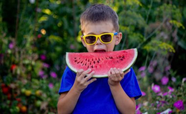 A child eats a watermelon. Selective focus. Nature