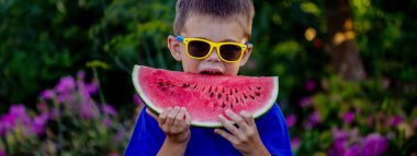 A child eats a watermelon. Selective focus. Nature