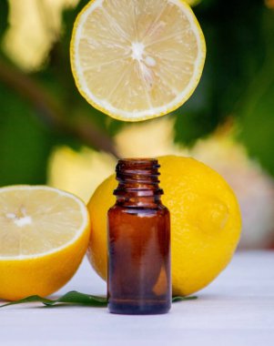 Tahta bir tahtanın üzerinde limon yağı ve limon meyvesi. Seçici odak