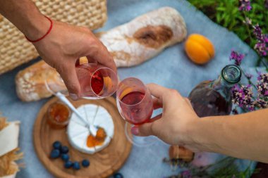 Lavanta tarlasında romantik bir piknik için lezzetli yiyeceklerle dolu bir sepet şarap, meyve, dut. Seçici odaklanma. Doğa