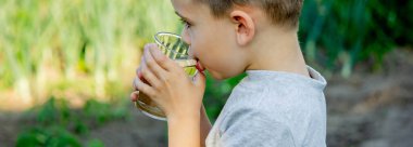 Sevimli küçük çocuk bardaktan su içiyor. Seçici odak