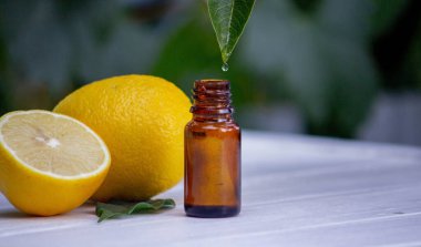 Limon esanslı yağ bir yapraktan damlıyor. Seçici odaklanma. Doğa