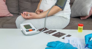 Doktor hamile bir kadının baskısını ölçer. Seçici odaklanma. ilaç.