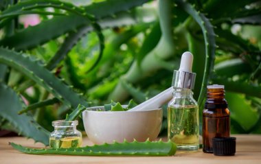 Ahşap arka planda aloe vera esaslı yağ, meyve suyu. Seçici odak