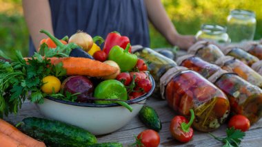 A woman preserves vegetables in jars. Selective focus. Food.