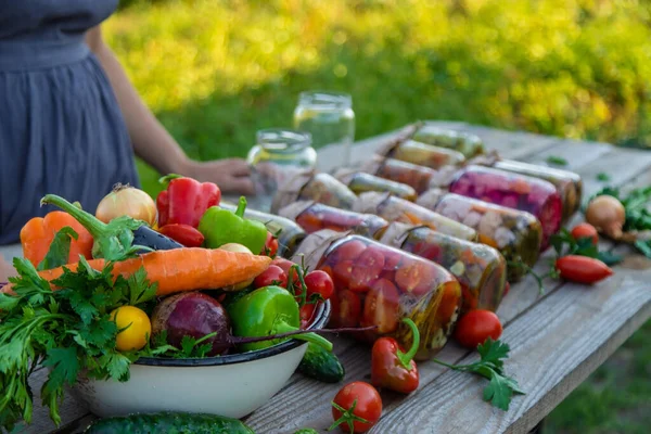 A woman preserves vegetables in jars. Selective focus. Food.