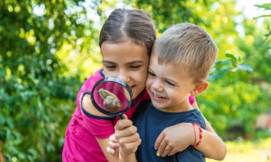 Çocuk salyangoz doğasına bakıyor. Seçici odaklanma. Hayvan..