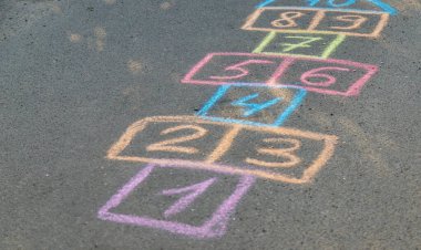 Arka bahçe klasikleri asfalt zeminde tebeşirle çizilmiş sayı ve karelerle. Seçici odaklanma. Doğa