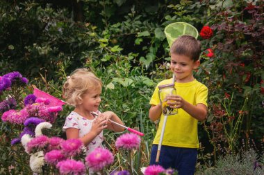 Çocuklar kavanozda kelebek yakalar. Seçici odaklanma. Doğa