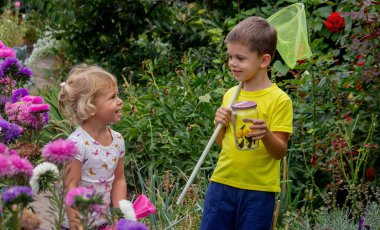 Çocuklar kavanozda kelebek yakalar. Seçici odaklanma. Doğa