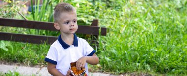 Bir çocuk parkta cips yiyor. Seçici odaklanma. Doğa