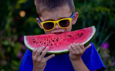 A child eats a watermelon. Selective focus. Nature