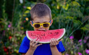 A child eats a watermelon. Selective focus. Nature