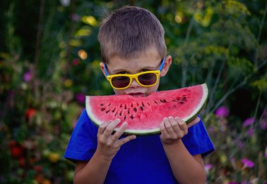 A child eats a watermelon. Selective focus. Nature