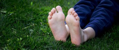 Yeşil çimlerin üzerinde çocuk bacakları. Seçici odaklanma. çocuk