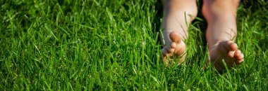 Yeşil çimlerin üzerinde çocuk bacakları. Seçici odaklanma. çocuk