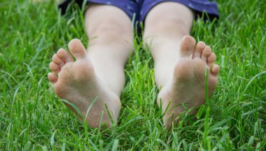 Yeşil çimlerin üzerinde çocuk bacakları. Seçici odaklanma. çocuk