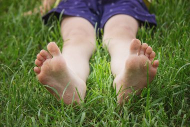 Yeşil çimlerin üzerinde çocuk bacakları. Seçici odaklanma. çocuk