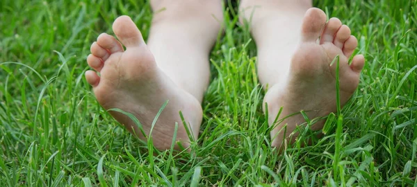 Yeşil çimlerin üzerinde çocuk bacakları. Seçici odaklanma. çocuk