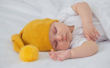 Yatakta uyuyan çocuk oyuncak ayıyı tutuyor. Seçici odak