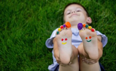 a smile painted with paints on the child's arms and legs. Selective focus