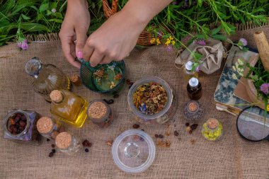 Bir kadın bitkisel tentür üretiyor. Seçici odaklanma. Doğa.