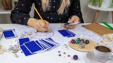 Woman astrologer draws a natal chart. Selective focus. People.