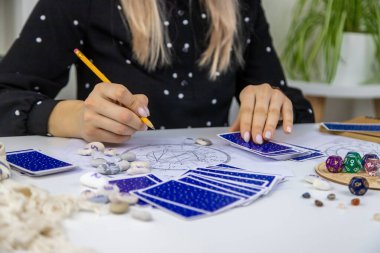 Woman astrologer draws a natal chart. Selective focus. People.