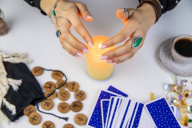 Woman fortune teller fortune telling on a candle. Selective focus. people.