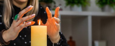 Woman fortune teller fortune telling on a candle. Selective focus. people.