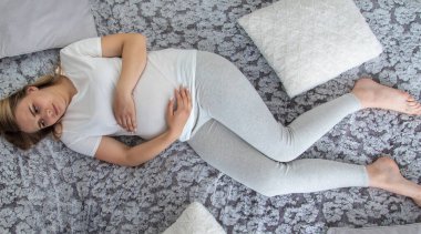 Hamile kadının midesi ağrıyor. Seçici odaklanma. Ev.