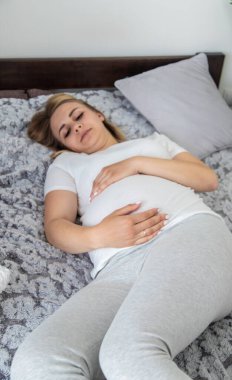 Hamile kadının midesi ağrıyor. Seçici odaklanma. Ev.