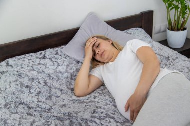 Hamile kadının başı ağrıyormuş. Seçici odaklanma. Ev.