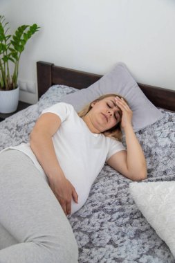 Hamile kadının başı ağrıyormuş. Seçici odaklanma. Ev.