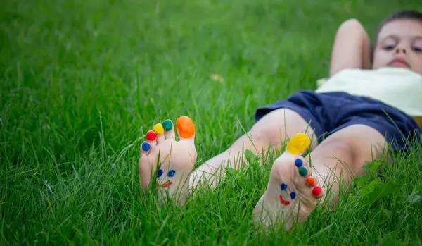a smile drawn with paints on a child's legs.