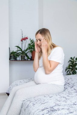 Hamile kadının başı ağrıyormuş. Seçici odaklanma. Ev.