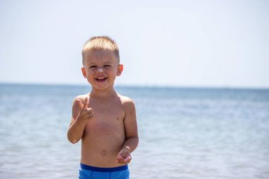 Çocuk kendine güneş kremi sürüyor. Güneşten korunma