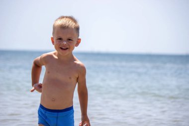 Çocuk kendine güneş kremi sürüyor. Güneşten korunma