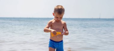 Çocuk kendine güneş kremi sürüyor. Güneşten korunma