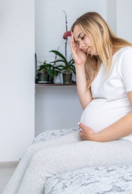 Hamile kadının başı ağrıyormuş. Seçici odaklanma. Ev.