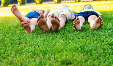 Yazın yeşil çimlerde koşan çocukların ayaklarına yakın çekim