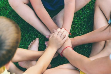 Üç çocuk, sokakta oynarken ellerini kavuşturdu. yaz.