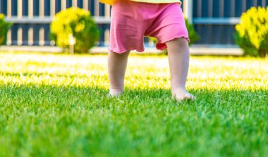 Çocukların bacakları yeşil çimlerde koşar. çocuklar