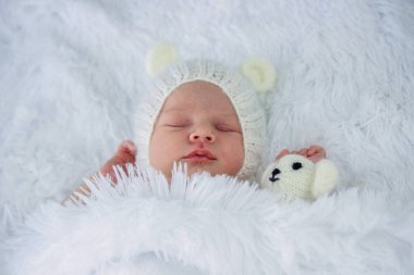 Tatlı küçük kız oyuncak ayıyla uyuyor.