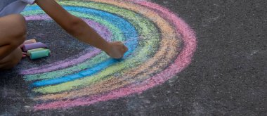 Çocuk asfalta tebeşirle çiziyor. Seçici odak.