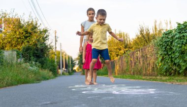Çocuklar asfaltta klasik bir oyun oynarlar. Seçici odak.